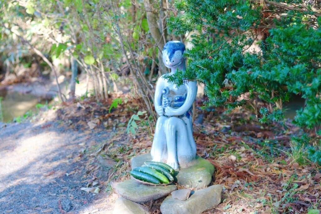 Kappa statue near Kappabuchi. Cucumbers are offered at its feet,