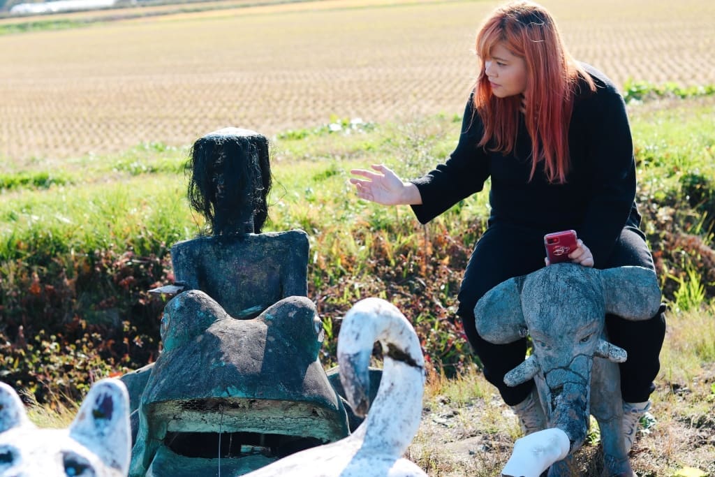 Mizhelle talking to a kappa statue