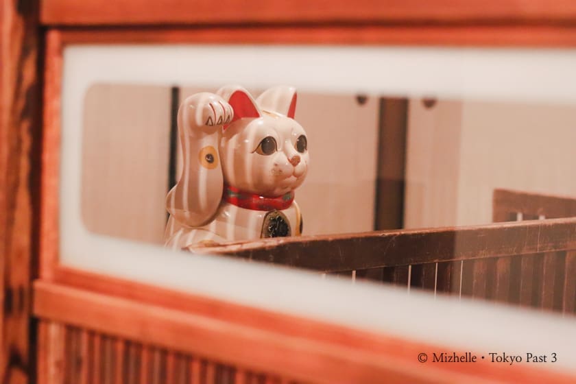 Peek through a wooden door and you'll see a maneki neko (lucky cat)